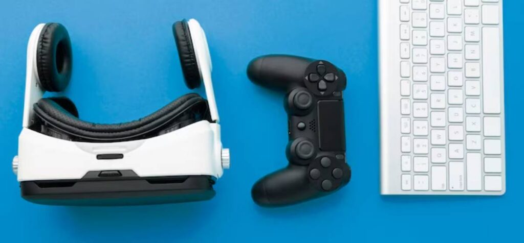 Top view of a white virtual reality headset, black game controller, and a sleek white keyboard on a blue background.
