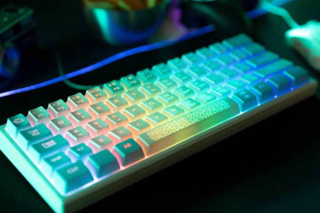 A close-up of a backlit gaming keyboard with colorful RGB lighting, showcasing vibrant keys set against a dark background.