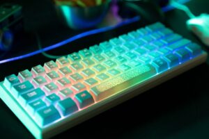 A close-up of a backlit gaming keyboard with colorful RGB lighting, showcasing vibrant keys set against a dark background.