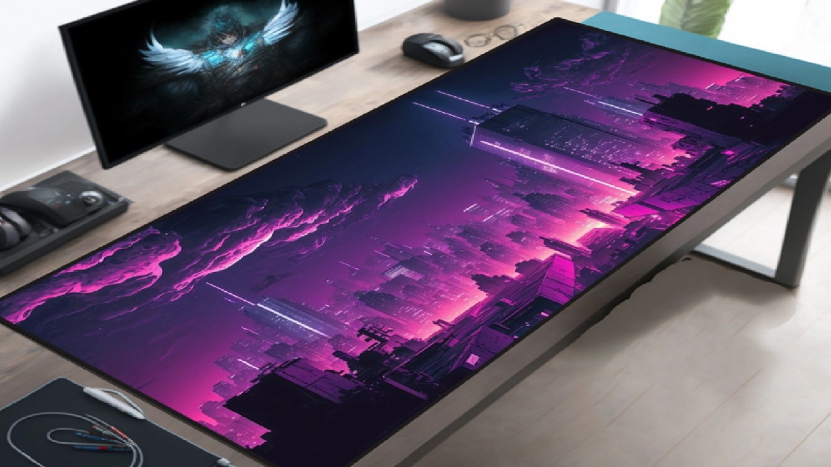 A desk with a vibrant purple cityscape mousepad, a monitor displaying a dark-themed image, and gaming accessories nearby.