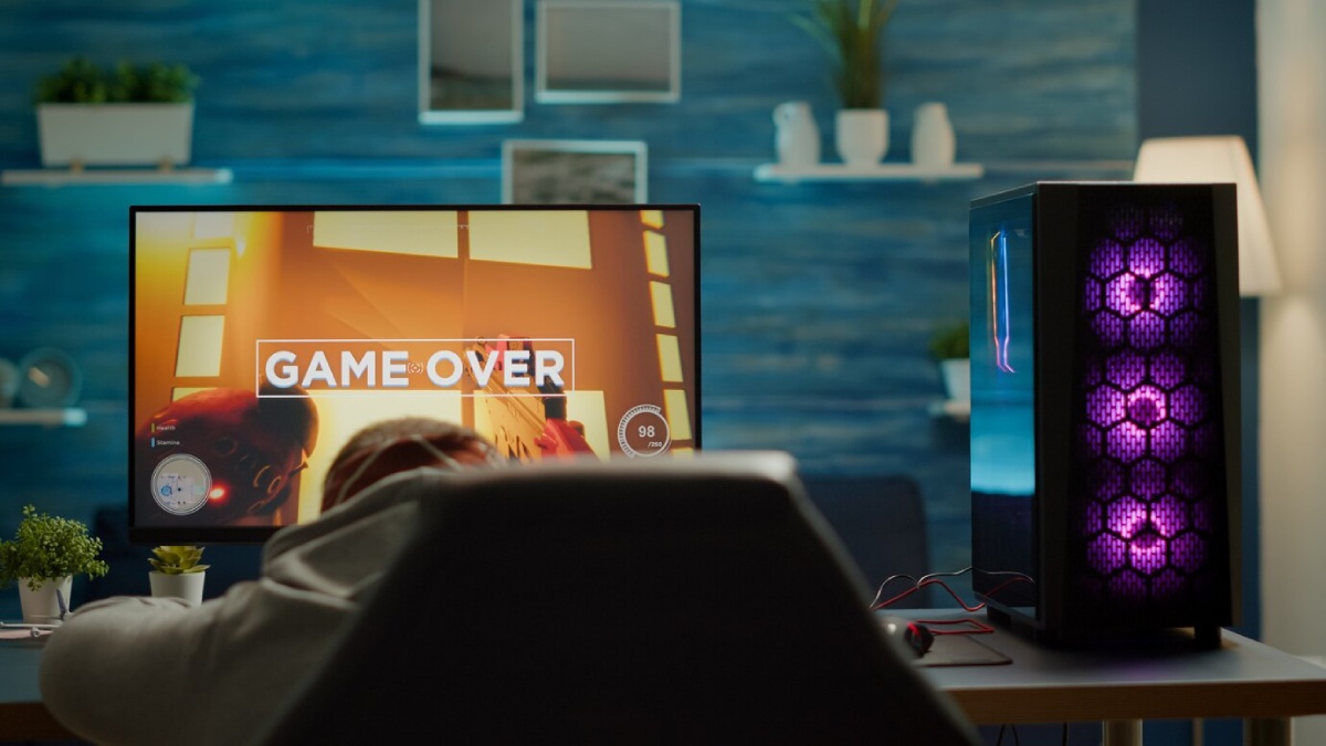 A gamer slouches in a chair, facing a screen displaying 
