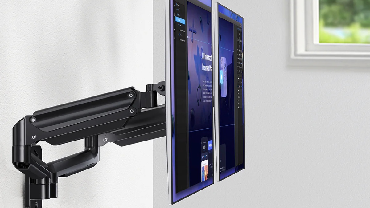 Dual monitors mounted on an adjustable black arm, with a modern interface displayed, against a light-colored wall.