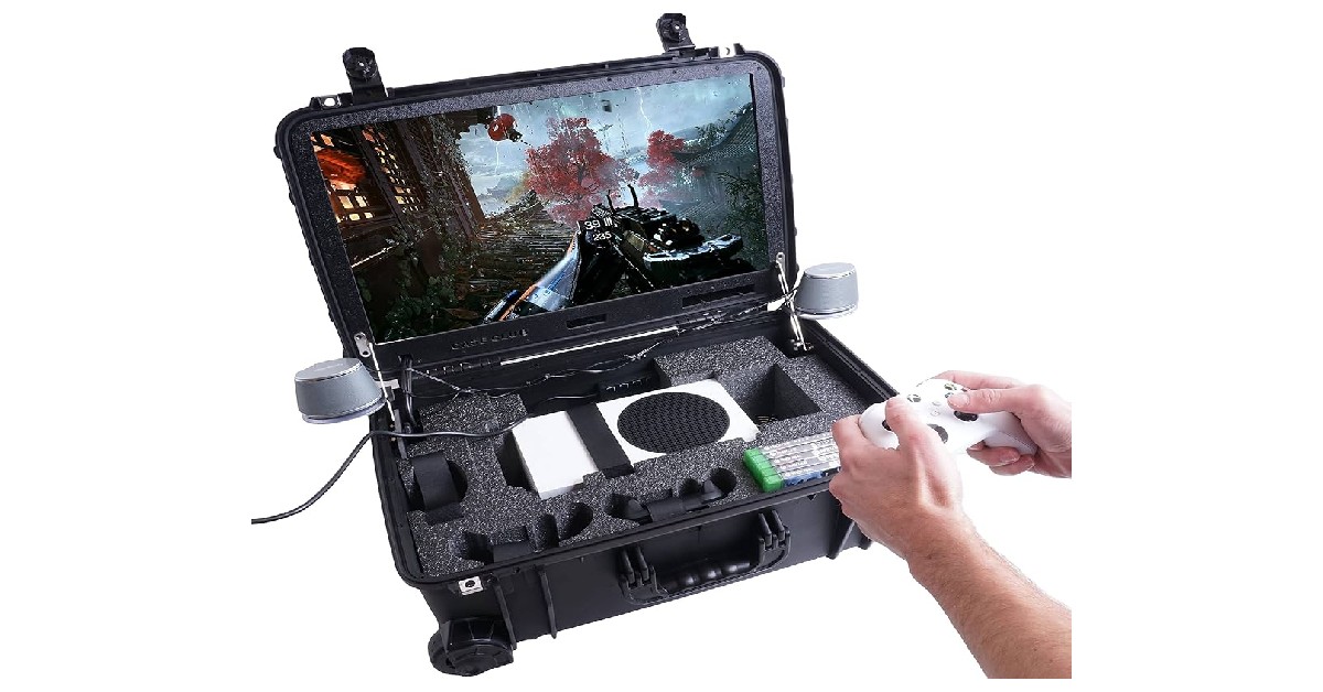 A person holds a game controller while playing on a portable gaming setup inside a rugged case with a screen and organized components.
